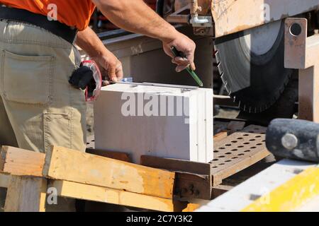 Construction worker (bricklayer) works on the construction site Stock Photo