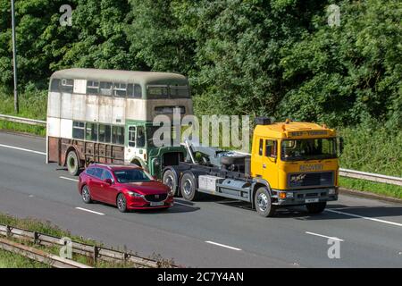 MEP Recovery 1967 60s Leyland Titan Bus (front engined double decker towed by 1993 ERF tow truck, for restoration. UK vehicular traffic derelict condition, rare collectible vintage classic transport on tow, towed rusty old buses, double decker classics north-bound on the M6 Motorway highway. Stock Photo