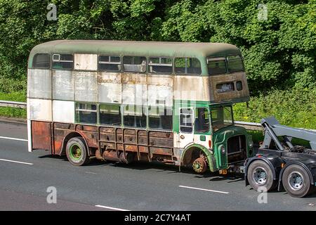 MEP Recovery 1967 60s Leyland Titan Bus (front engined double decker towed by 1993 ERF tow truck, for restoration. UK vehicular traffic derelict condition, rare collectible vintage classic transport on tow, towed rusty old buses, double decker classics north-bound on the M6 Motorway highway. Stock Photo