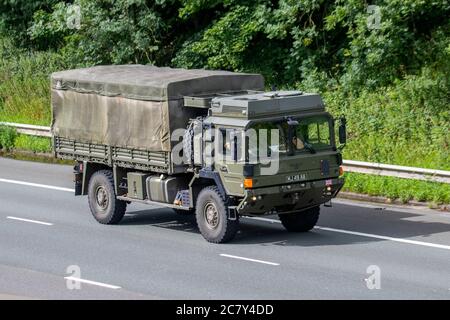 Canvas-covered MAN HX60 18.330 4x4 diesel British Army Truck MJ49AB; Heavy bulk haulage delivery trucks, haulage, lorry, transportation, truck, cargo, vehicle, delivery, transport, industry, freight, on the M6 at Lancaster, UK Stock Photo