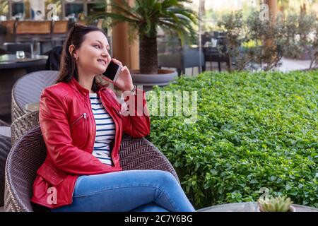 Young woman speak with phone and have a happy face in an elegance cafe. High quality photo Stock Photo