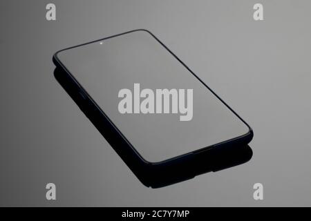 Black large screen smartphone with shadow on glass surface Stock Photo