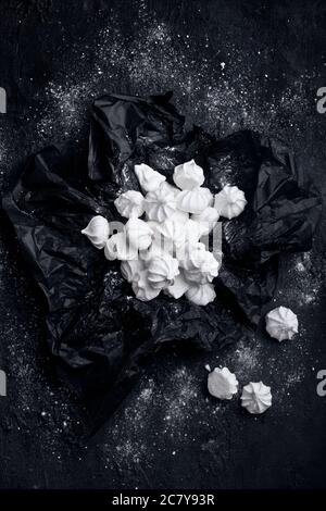 many small white meringues with crunches isolated on black background, nobody Stock Photo