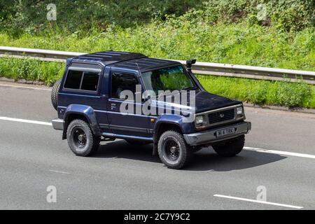 1996 90s blue Daihatsu Fourtrak IND TDX SE; Vehicular traffic moving vehicles, number plate spacing rules, illegal spacing on number plates, illegal number plates on cars, driving vehicle on UK roads, motors, motoring on the M6 motorway highway network. Stock Photo