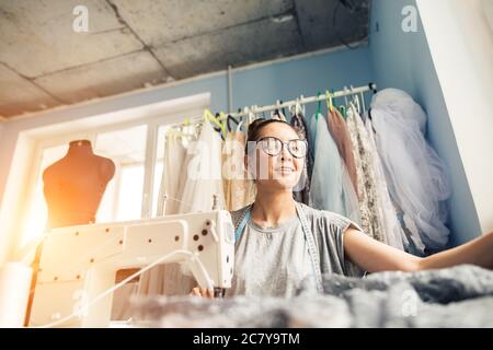 Woman tailor working on sewing machine. Hands. close up. Tailoring. Details. Stock Photo