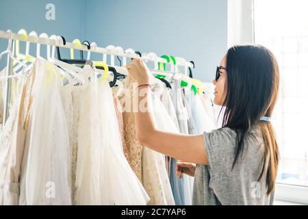 A portrait of a young fashion designer or Tailor working on a design or draft, she make a little adjustment to her work Stock Photo
