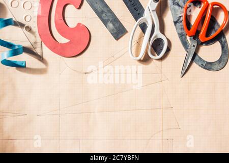 Still life photo of a suit pattern template with tape measure, chalk and scissors. Sewing and tailoring tools and accesories. Stock Photo