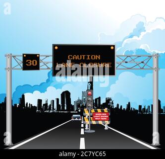 Roadway overhead digital gantry sign with caution roadworks lane closure message and temporary traffic lights set against a blue cloudy sky Stock Photo