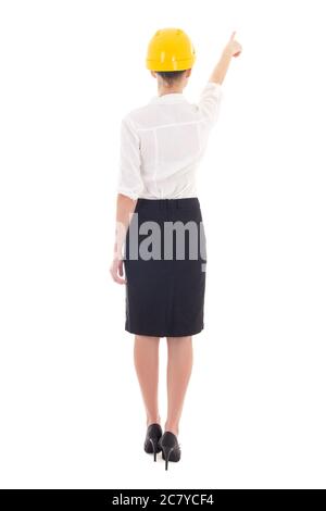 rear view of business woman architect in yellow builder helmet pointing at something isolated on white background Stock Photo