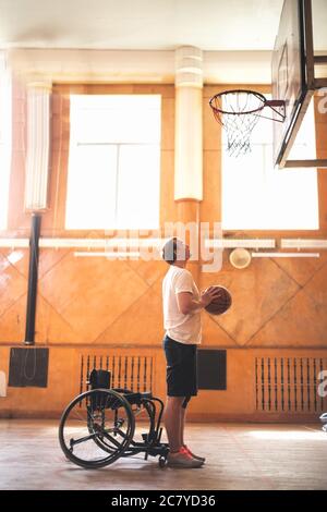 Wheelchair basketball player with ball on his lap Stock Photo