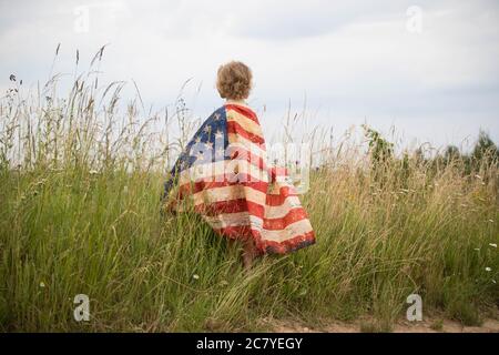 Patriotic holiday. Happy kid, cute little child girl with American flag. Stock Photo