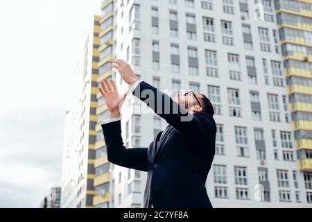 senior builder in hardhats pointing workers outdoors Stock Photo