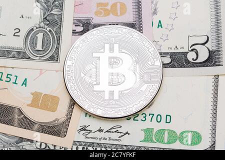 Silver bitcoin on US dollars, micro shot. Stock Photo