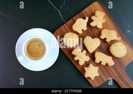 Adorable Homemade Animal and Heart Shaped Cookie with a Cup of Coffee on Black Table Stock Photo