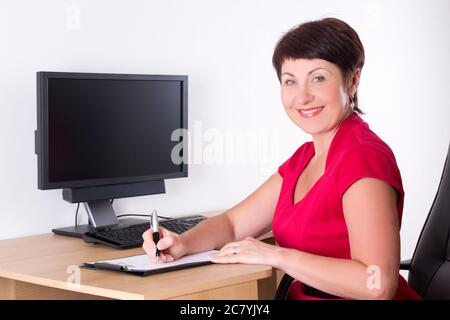happy middle aged businesswoman sitting in office Stock Photo