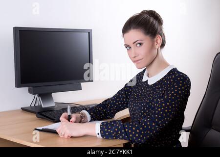 young beautiful business woman in office using computer with empty monitor screen Stock Photo