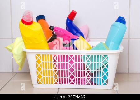 cleaning supplies in plastic box on tiled floor in bathroom Stock Photo