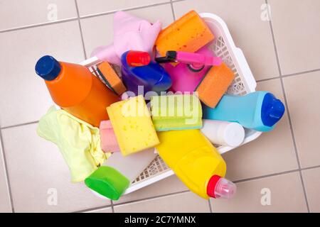 full box of cleaning supplies on tiled floor in bathroom Stock Photo