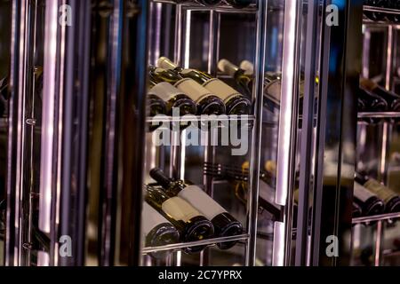 Resting wine bottles stacked on wooden racks in cellar Stock Photo