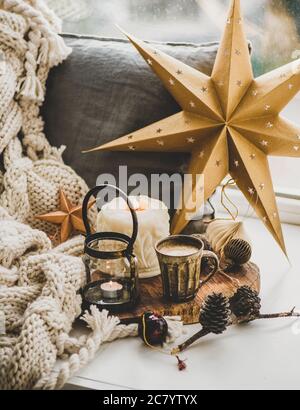 Christmas composition with coffee, candles and decorative toys on windowsill Stock Photo