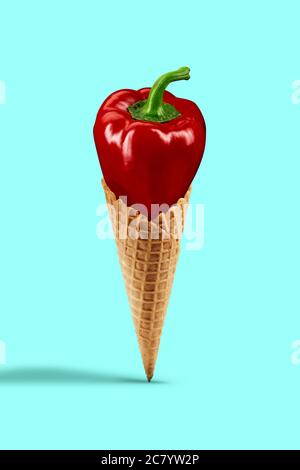 Ripe red bell pepper in a wafer cone against turquoise background. Healthy nutrition and seasonal vegetables harvest. Close up, copy space Stock Photo