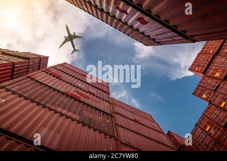 Airplane flying above container logistic. Cargo and shipping business. Container ship for import and export logistic. Logistic industry from port to Stock Photo