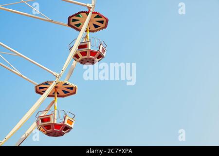 Retro toned close up picture of two Ferris wheel cars with cloudless sky, space for text. Stock Photo