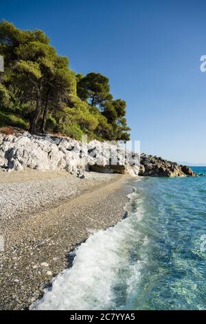 Light surf on the famous Kastani beach of Skopelos in summer with clear blue sea. Stock Photo