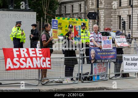 Free Julian Assange protester with placard outside Parliament in Westminster, London, UK Stock Photo