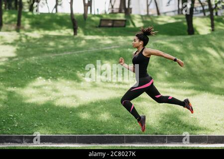 Jump and running outdoors at nature. Girl in sport uniform froze in air Stock Photo