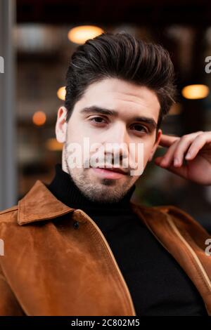 Portrait of young attractive man confidently looking in camera outdoor Stock Photo