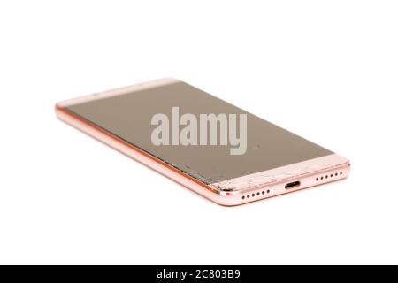 New pink slim smartphone with cracked screen from corner isolated on white background Stock Photo
