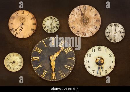 Set of vintage clocks hanging on an old weathered brown wall Stock Photo