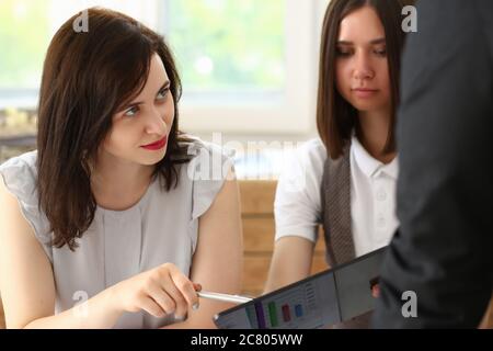 Two female managers discussing working plan with man Stock Photo