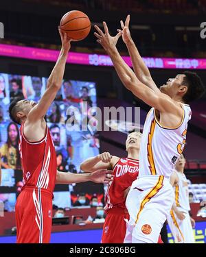 Qingdao(Shandong. 20th July, 2020. Ren Junwei (L) of Shanxi Loongs is  defended by Yang Jinmeng of Qingdao Eagles during a match between Shanxi  Loongs and Qingdao Eagles at the 2019-2020 Chinese Basketball