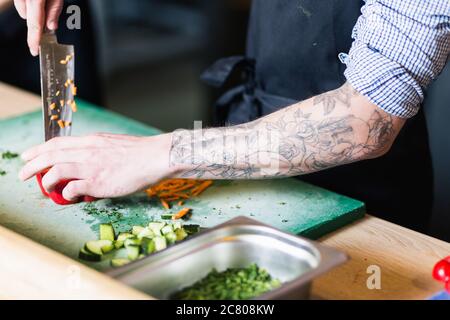 Cook's hands preparing vegetable salad - closeup shot Stock Photo