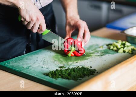 Cook's hands preparing vegetable salad - closeup shot Stock Photo
