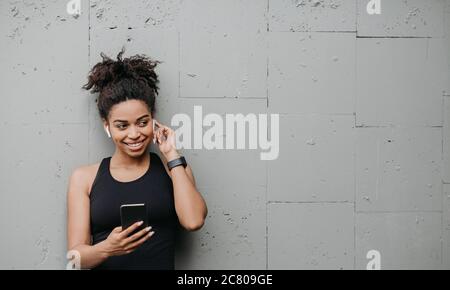 The girl in sportswear. In his hand smartphone. Runs on jogging, in the  morning in the summer in the city. Sports and healthy lifestyle. Beautiful  Tattoos on tanned female skin Stock Photo 