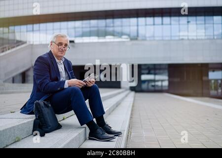 Senior businessman using tablet  in a cityscape Stock Photo