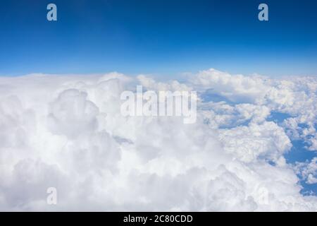 Powerful cumulus clouds in unstable stratification of the troposphere, weather with short-term rains and thunderstorms, aerial view Stock Photo