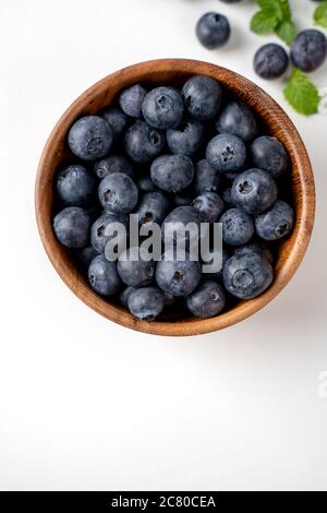 Blueberry fruit top view isolated on a white background, flat lay overhead layout with mint leaf, healthy design concept. Stock Photo