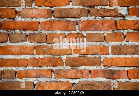 An old red brick wall with cracks. Close up. Stock Photo