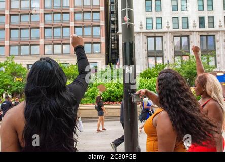 Chicago, IL, USA. 18th July, 2020. Three women raise their fist in solidarity as Black Lives Matter protesters march north on Michigan Ave. in Chicago, July 18, 2020. Credit: Dominic Gwinn/ZUMA Wire/Alamy Live News Stock Photo