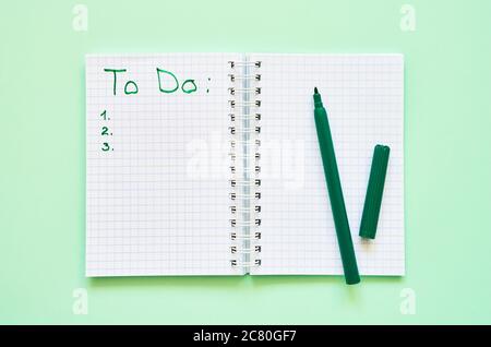 Back to school concept. Opened personal organizer with a to do list on green background. Top view, copy space for text. Stock Photo