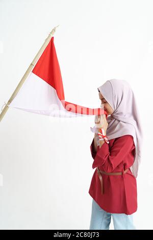 portrait of young asian woman with scarf kissing red and white flag of indonesia Stock Photo