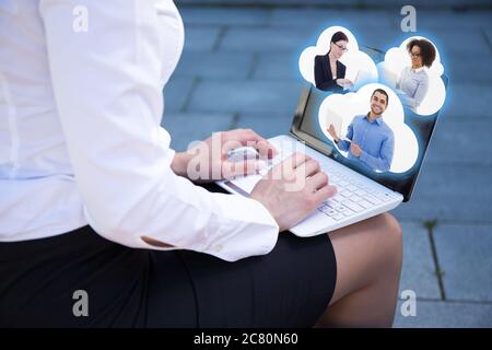 business woman using laptop and clouds with her friends or business partners Stock Photo