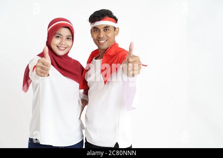 indonesian couple celebrating indonesia independence day together over white background showing thumb up Stock Photo
