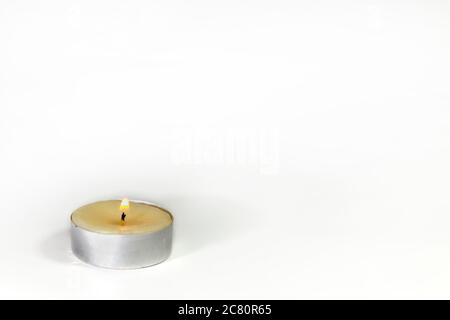 small decorative wax candle. Burning wax candle on white background, high key Stock Photo