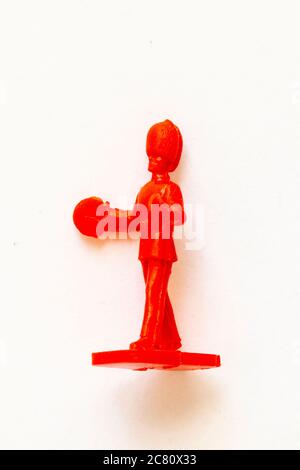 Airfix 1960 HO/00 scale figure from the Guards Band series. Toy Guardsman marching and playing the cymbals, modelled in red plastic. White background. Stock Photo