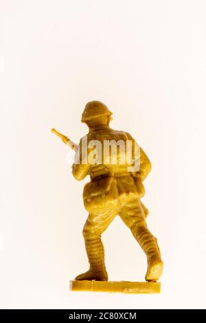 Airfix HO/00 scale model Japanese soldier figure from the 1960's against plain background. Close up of advancing WW2 soldier holding gun. Stock Photo